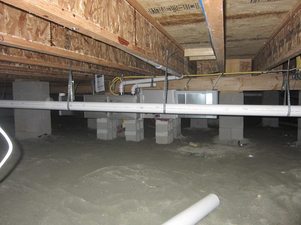 A Charlotte-area crawl space of the type we encapsulate — block piers, joists, and a dirt floor